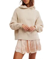 Hoodie de punto color crema, con capucha, manga larga abullonada y diseño oversized. Presenta tejido trenzado con patrones de rombos y textura de punto arroz en el cuerpo y mangas.