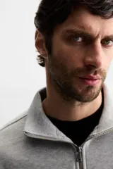 Sudadera color crema de corte recto, con cuello polo y cierre de cremallera metálica.