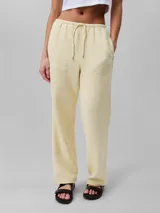 Pantalón de gasa doble color amarillo pálido, de corte recto y cintura elástica con cordones.
