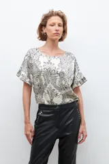 Blusa color crudo con estampado paisley, escote redondo y mangas cortas con volados.