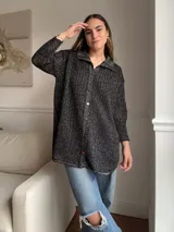 Camisa de tejido calado color negro con brillo, de corte holgado y mangas largas.