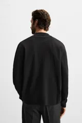 Cárdigan negro de punto de algodón, corte regular, con cuello solapa, manga larga, bolsillo de parche en el pecho y cierre frontal con botones.