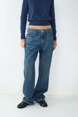 Jean de tiro alto color azul denim, corte loose con pernera ancha. Diseño clásico de cinco bolsillos con cierre de cremallera y botón metálico.