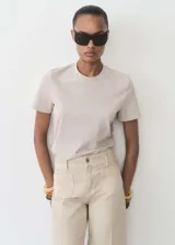 Remera color beige de corte recto, cuello redondo y mangas cortas.