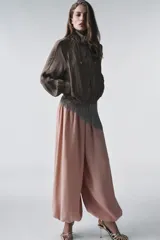 Pantalón bombacho de lyocell color rosa pálido, con cintura elástica y lazos ajustables en los tobillos.