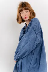 Camisa oversize blanca de algodón con pliegues frontales.