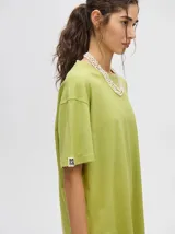 Remera verde con estampado de un velero en el pecho, corte cuadrado y holgado.