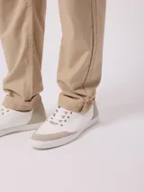 Pantalón de vestir color beige, de corte recto, con bolsillos laterales y traseros. Se ajusta a la cintura con botón y cierre.