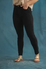 Pantalón jean negro de corte skinny con tiro alto.