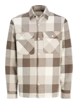 Sobrecamisa a cuadros marrón, beige y blanco, de manga larga y cuello camisero. Tiene cierre con botones, bolsillos en el pecho con solapa y broche, y corte confort.