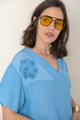 Blusa italiana color crudo de lino con escote en V y mangas cortas. Presenta detalle de bordado calado en el canesú.