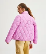 Campera femenina de poliamida color lila con textura capitoneada, cuello alto, cierre frontal con cremallera, bolsillos laterales con cremallera y puños ajustados.