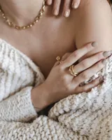 Anillo dorado con diseño de tres bandas entrelazadas.