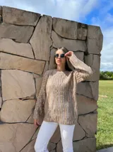 Sweater negro con rayas verticales plateadas, de cuello redondo y mangas largas.