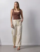 Pantalón palazzo color crema, marca Nanette, con pretina elastizada, lazo de ajuste y bolsillos delanteros.