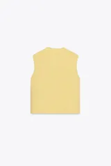 Chaleco amarillo de punto con cuello redondo y sisas amplias. Tiene cierre frontal con botones dorados y dos bolsillos de parche con botón.