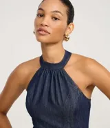 Vestido midi de jeans azul, con frente única, sin mangas y espalda descubierta.