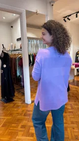 Sweater lila de tejido de punto fino con cuello redondo y mangas largas. Presenta líneas horizontales de strass plateado en el frente.