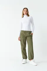 Polera blanca de cuello alto y manga larga, ajustada al cuerpo.