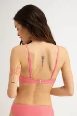 Top de bikini triangular color rosa con textura acanalada y tirantes finos.