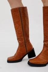 Botas bucaneras de cuero color negro, con caña alta y taco cuadrado.