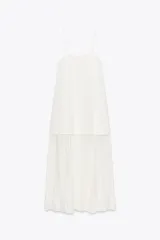 Vestido largo blanco de escote recto y tirantes finos. Falda con tejido plisado combinado a tono.