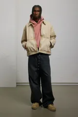 Campera color beige de sarga de algodón con efecto lavado, corte holgado, cuello clásico, cierre frontal con cremallera, bolsillos delanteros de parche, bolsillo interior con botón a presión, botones a presión ajustables en los puños y en los laterales del bajo y forro interior.