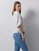 Blusa de gasa blanca, marca Sioni. Cuello a la base y escote en V con botones.