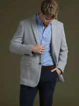 Blazer azul marino de corte clásico con solapa de muesca, cierre de dos botones y bolsillos laterales con solapa.