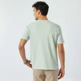Remera de manga corta color verde claro, con cuello redondo y textura de punto jacquard.