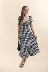 Vestido midi con estampado a cuadros blanco y negro, escote corazón con detalle de puntilla y mangas cortas abullonadas.