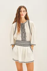 Minifalda blanca de algodón con bordados geométricos negros en el ruedo y cintura.