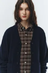 Cardigan de punto azul marino, con cuello en V, botones frontales y puños y ruedo acanalados.