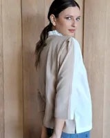 Camisa de manga larga color blanco y beige, con cuello con volados y cierre frontal con botones.