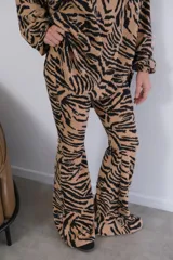 Conjunto de pantalón y camisa con estampado animal print tipo cebra en blanco y negro. La camisa es de manga larga con cierre de cremallera y el pantalón es acampanado.