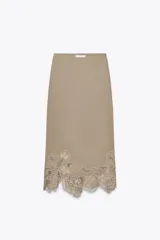 Falda midi color beige con bordado de flores en el ruedo.