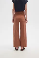 Pantalón de jean color beige, de corte flare y tiro alto, con terminación desflecada.