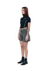 Top negro cropped de gabardina elastizada, con cuello alto, cierre frontal y mangas cortas. Diseño entallado con recortes y costuras a contratono blancas. Logo Temblad en el pecho.