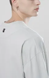 Remera manga larga gris con puños y cuello de ribb al tono, calce regular.