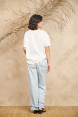 Pantalón de jean celeste de corte ancho con apliques bordados y desflecados.