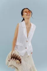 Chaleco blanco de lino con cuello solapa, sin mangas y corte recto.