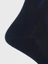 Calcetín formal de largo medio, color azul marino, con la marca "Hush Puppies" tejida en azul más oscuro en la caña.