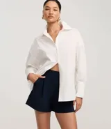 Short de vestir azul marino, de corte recto y tiro alto, con pliegues frontales y trabillas en la cintura.