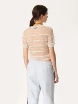 Top de encaje negro con cuello redondo y mangas cortas con volados.