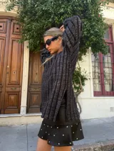 Minifalda negra de cuero sintético con volados y tachas plateadas.