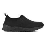 Zapato de vestir negro, tipo mocasín, sin cordones, con elásticos laterales y suela gruesa.