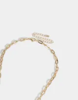 Collar corto con cadena de eslabones dorados y multidijes plateados y dorados con forma de corazón, trébol, herradura, caballo, bota de cowboy y estrella.