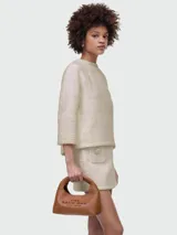 Bolso de mano tipo hobo, color marrón cuero, con asas cortas y texto estampado en el frente que dice "THE SACK BAG MARC JACOBS".