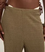 Pantalón wide color marrón claro con cintura elástica y textura acanalada.