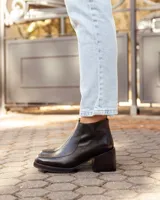 Botinetas de cuero negro con diseño de punta cuadrada y taco bloque. Presentan cierre lateral para facilitar el calce y una textura sutil en la puntera.